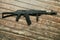 Black machine gun on the background of shabby wooden floor