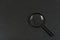 Black magnifying glass on black background. Magnifier. Search