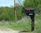 Black mailbox with prints and numbers erected on the roadside