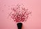 Black make-up brush and circle crimson glitter confetti on a pink background. Sparkles. Top view. Flat lay.