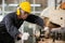 Black male african american workers wear sound proof headphones and yellow helmet working.