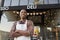 Black male business owner standing outside coffee shop