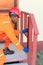 Black male carpenter taking measurements outside a house. Repairing the house