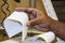 Black male cashiers hand taking sales slip from cash register with phone line hanging in background