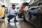 Black Male Customer Choosing New Automobile In Dealership Center, Examining Wheel Rims