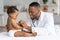 Black Male Pediatrician Listening Child& x27;s Heartbeat With Stethoscope During Checkup At Home