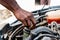 Black man as Auto mechanic working in garage near car engine. Repair service and transport concept. Hands of African American car