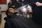 Black man in the barbershop. Cute black man makes a haircut in the African salon. Hair style. Haircut for adults