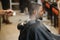 Black man in the barbershop. Cute black man makes a haircut in the African salon. Hair style. Haircut for adults