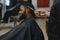 Black man in the barbershop. Cute black man makes a haircut in the African salon. Hair style. Haircut for adults