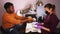Black man in a beauty salon shows his hands to master on workplace before making apparat manicure