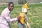 Black man in a California farm playing with a scarecrow