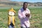 Black man in a California farm playing with a scarecrow