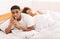 Black man cheater talking privately on cellphone in family bed