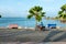 Black Man Cruising A Bridge Near The Port in Motorcycle With Palm Trees and Benches