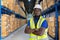 Black Man with Hard Hat in Folded Arm Pose with Cargos in a Warehouse