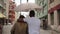 Black man holding an umbrella in his hands. Beautiful mixed race couple running along a city street while it is raining