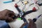 Black man mounting and soldering racing drone on wooden table