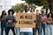 Black man with we need a change placard leading group