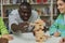 Black man playing balance tower game in library and moving piece