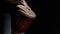 Black man plays drum with hands close-up in studio. Musician plays the traditional African drum in darkness. Artist