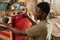 Black man refurbishing armchair in carpentry workshop