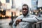 Black man runner with smartphone in an armband on the bridge in London, resting.