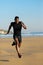 Black man running and sprinting at the beach