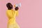 Black man shouting in megaphone on pink background portrait