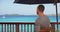 Black man on vacation sitting on deck looking over ocean view