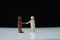 Black man and white man figurines shake hands