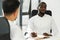 Black man in a white shirt is interviewing a new employee in a company.