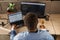 Black Man Writing Lines of Code On Desktop PC With Two Monitors and a Laptop Aside in Stylish Office. Professional Male