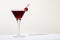 Black Manhattan cocktail with whiskey and red vermouth garnished with maraschino cocktail cherry in martini glass. Beige