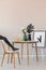 Black mannequin`s leg on wooden chair in elegant dining room interior with copy space on the empty wall