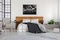 Black map on white wall above wooden headboard in simple bedroom interior