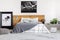 Black map on white wall above wooden headboard in simple bedroom interior