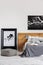 Black map on white wall above wooden headboard in simple bedroom interior