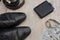 Black men`s shoes with accessories for care. Shoes, dollars, belt, wallet and wristwatch on a wooden background.