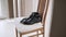 Black men shoes with leather belt and wristwatch stand on wooden chair.
