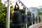 Black metal bells hung in row in thai temple and there is golden buddha statue behind them