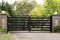Black metal driveway entrance gates set in fence