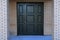 Black metal entrance door in brick house