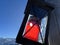 A black metal lantern with a red candle on a wooden crucifix with a wonderful winter panorama of the snow-covered Arosa