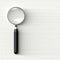 Black and Metal Magnifying Glass on a White Rough Surface with Copy Space.