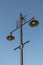 Black metal street light with decorative ornate castle design isolated against a blue sky