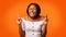Black Millennial Girl Holding Fingers Crossed Standing Over Orange Background