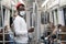 Black millennial man in red hat wearing face mask as protection against covid-19, flu virus, holding handrail in public transport