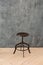 Black minimalist metal chair against grey background. Concept modern interior and design furniture in room. High stool in loft sty
