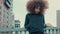 Black mixed race woman with big afro curly hair in outdoor city